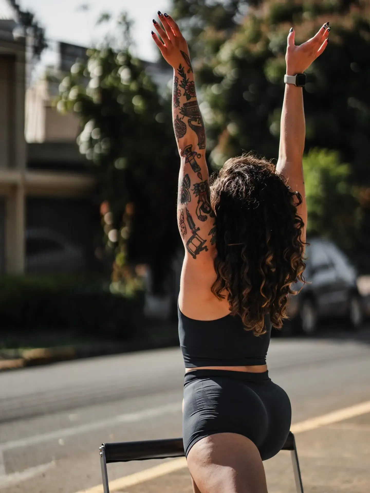 Mujer haciendo un estiramiento con los brazos elevados al aire libre